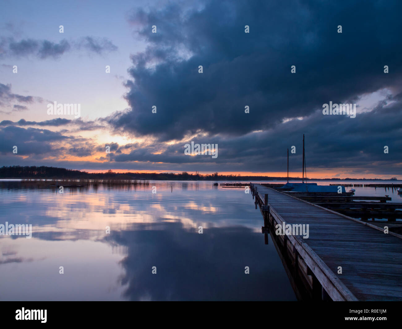 Sunset Jetty Rides Boats along a jetty during a tranquil sunset Stock Photo - Alamy