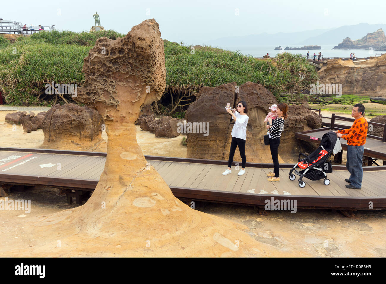 YEHLIU, TAIWAN - MARCH 30, 2017 : Some tourists are photographing an amazing geologic natural sandstone formation at the Yehliu geopark, Taiwan Stock Photo