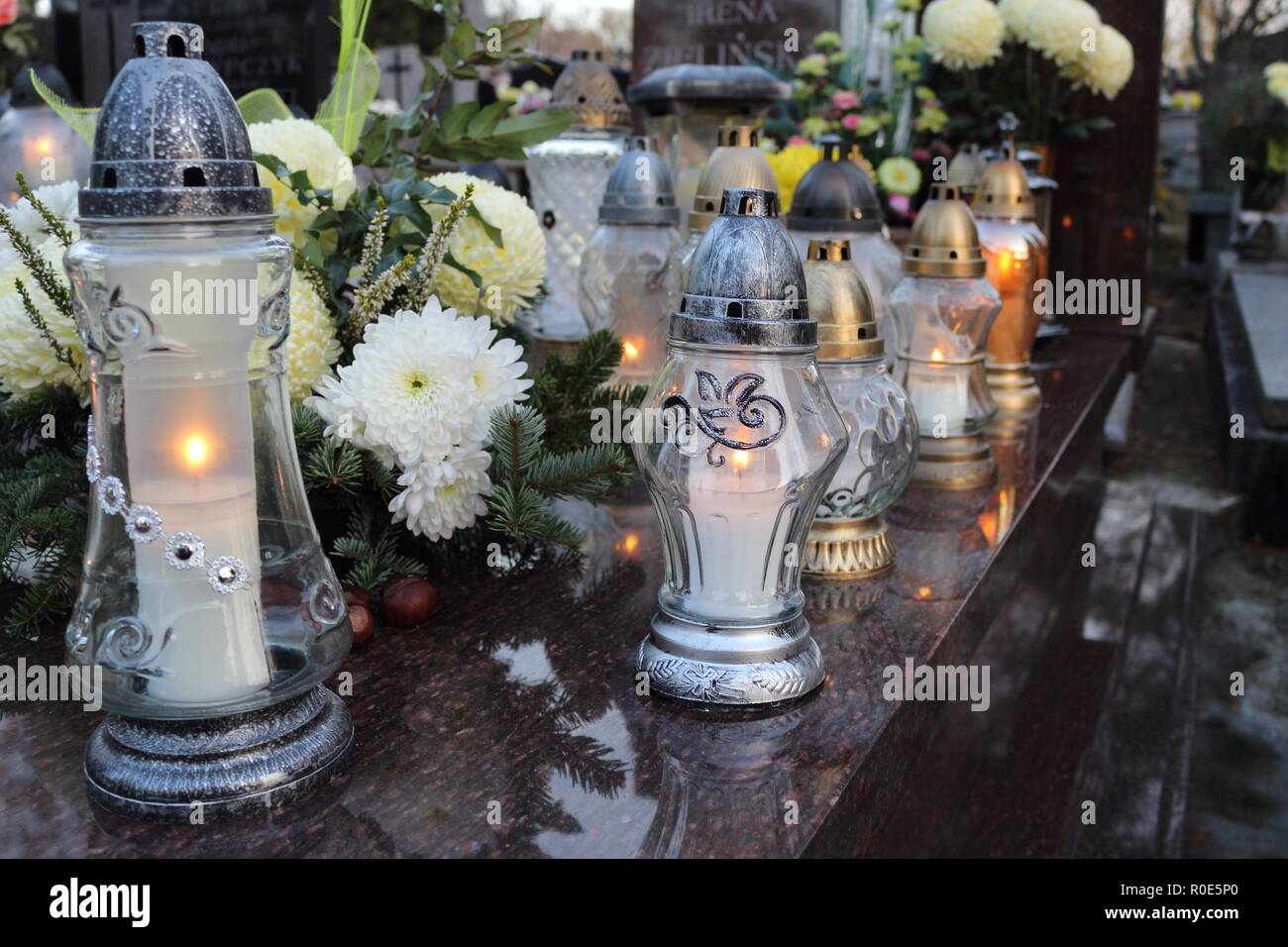 All Saints' Day. Candles on tombstone in old cemetery. Stock Photo