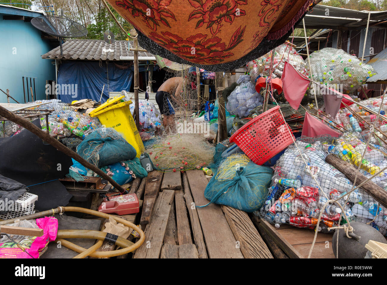 AO SALAD, THAILAND, JANUARY 31, 2016 : A man is selecting recyclable stuff at home in the AO Salad fishing village in Ko Kood Island, Thailand Stock Photo