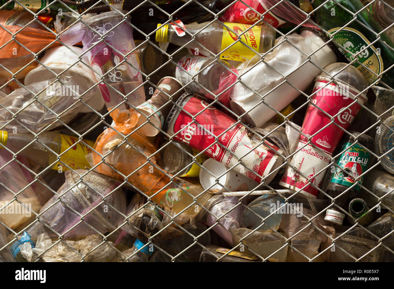 SANGHLABURI, THAILAND, JANUARY 24, 2016 : A fenced public bin is full of soda cans, glass bottel and other drinks in Sangkhlaburi, Thailand Stock Photo