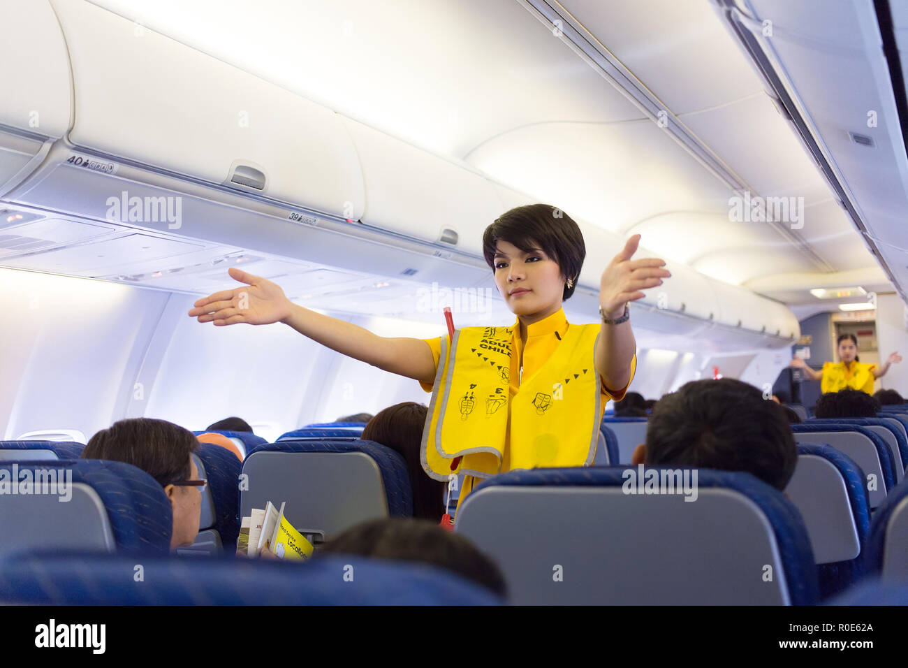 BANGKOK, THAILAND, JANUARY 05, 2016 : An air hostess of the Nok Air company is showing security rules before taking off from the Don Muang airport in  Stock Photo