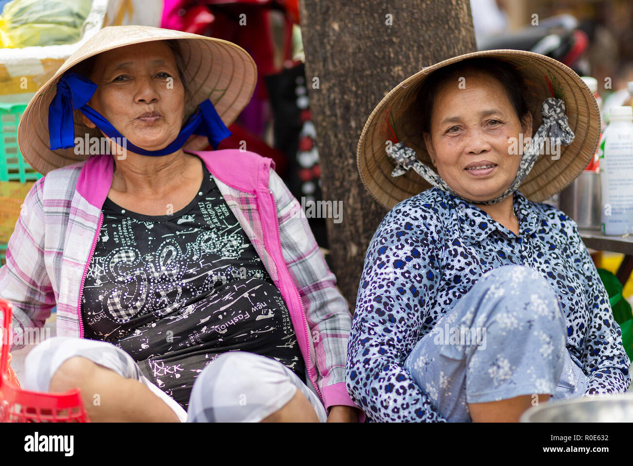 HO CHI MINH VILLE, VIETNAM, FEBRUARY 26, 2015 : Two friendly vegetable sellers are posing in the street of Chinatown in Ho Chi Minh Ville, (Saigon), V Stock Photo