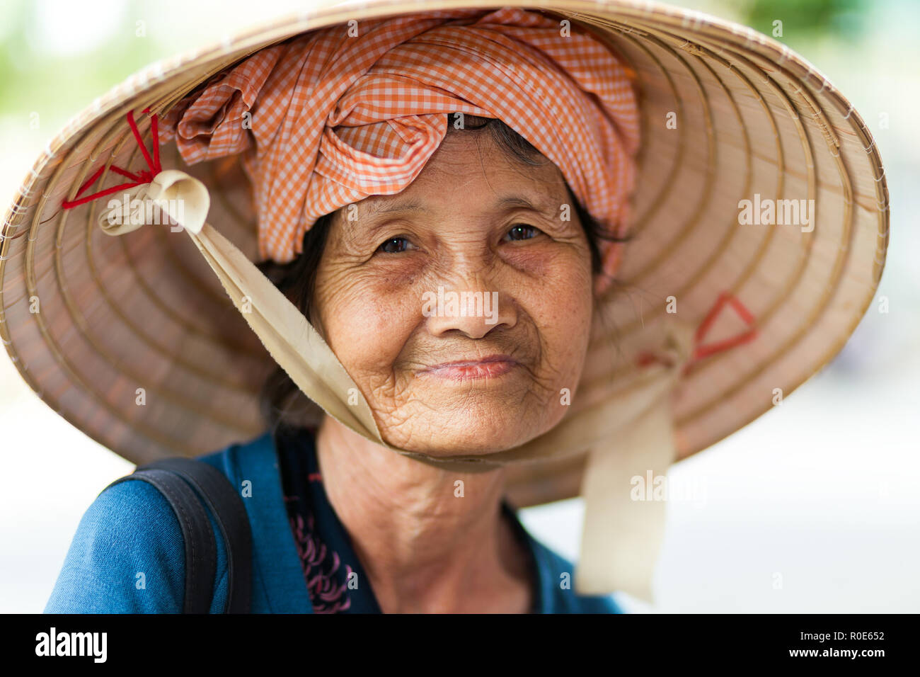 HO CHI MINH CITY ( SAIGON ), VIETNAM, FEBRUARY 22, 2015 : Portrait of a cute elderly lady wearing a traditional conical hat in Ho Chi Minh city, Vietn Stock Photo