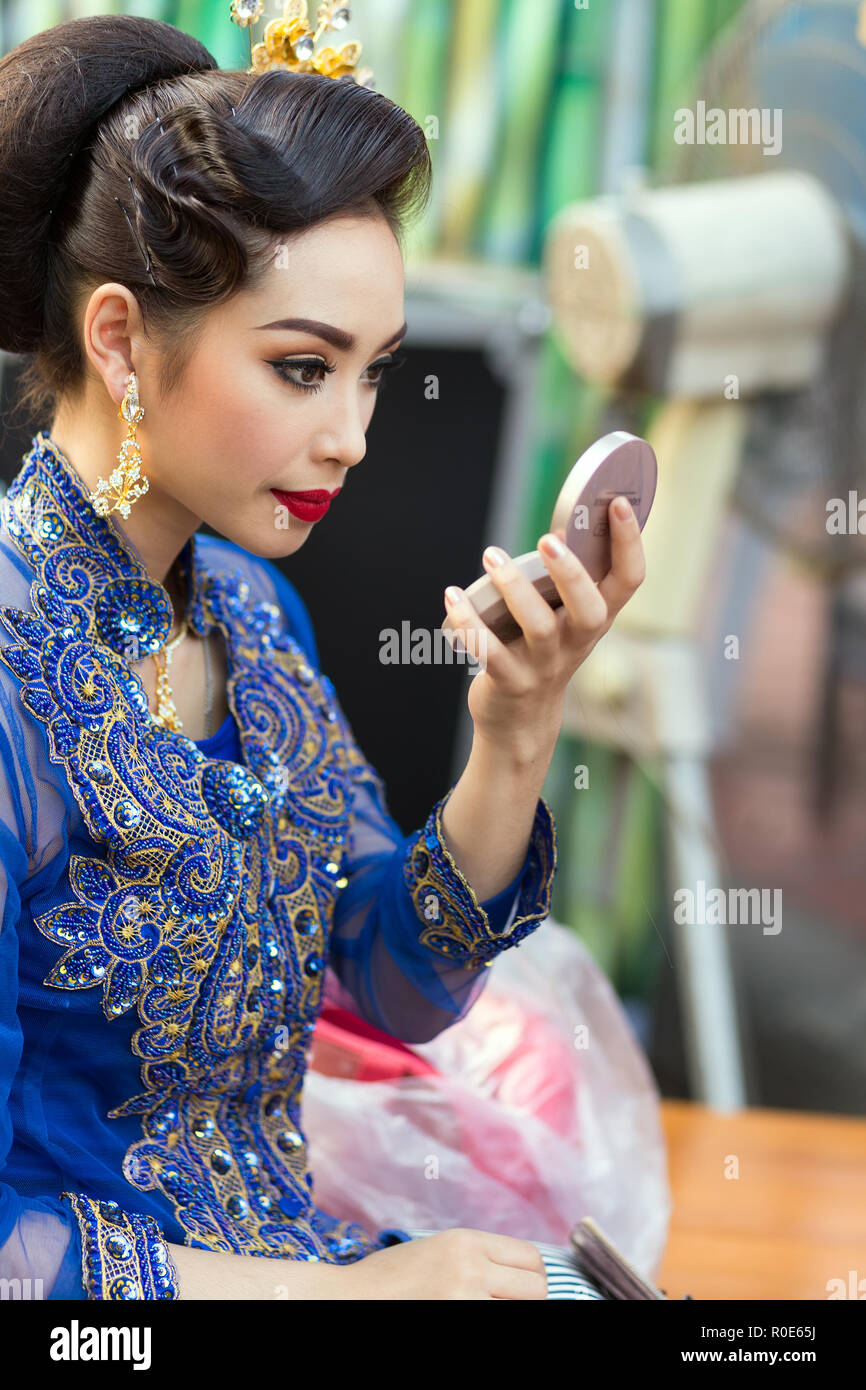 BANGKOK, THAILAND, February 17, 2015 : A Thai lady traditional dancer is checking her makeup before the show celebrating the new Krung Kasem floating  Stock Photo