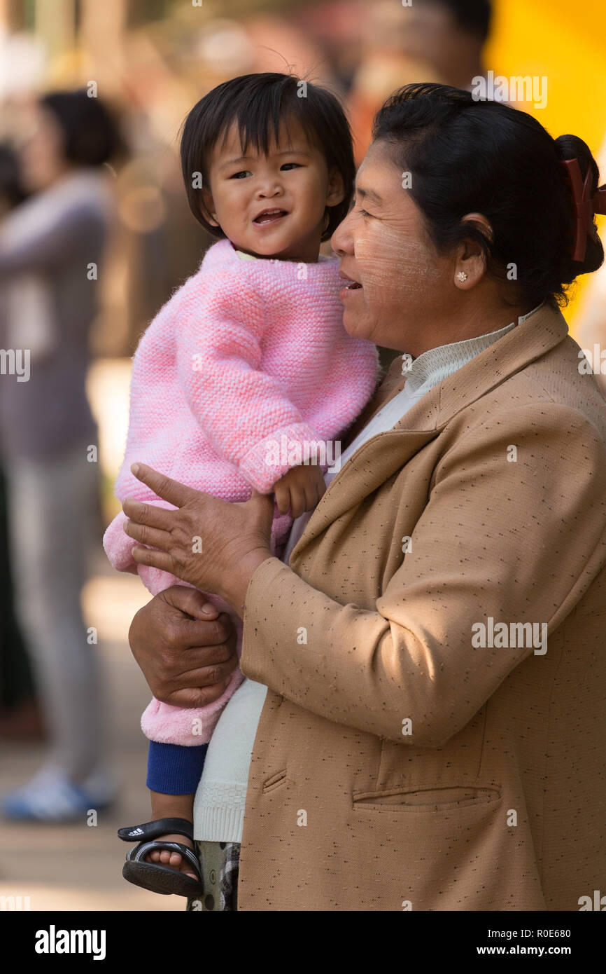BAGAN, MYANMAR, JANUARY 22, 2015: A Burmese woman is holding her little daughter in a street of Bagan, Myanmar (Burma) Stock Photo