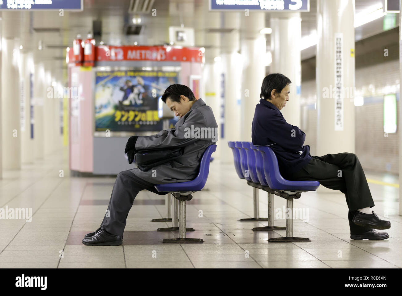 TOKYO - NOVEMBER 30: worker men waiting subway early morning and falling asleep on chairs on November 30, 2011 in Tokyo, Japan. Stock Photo