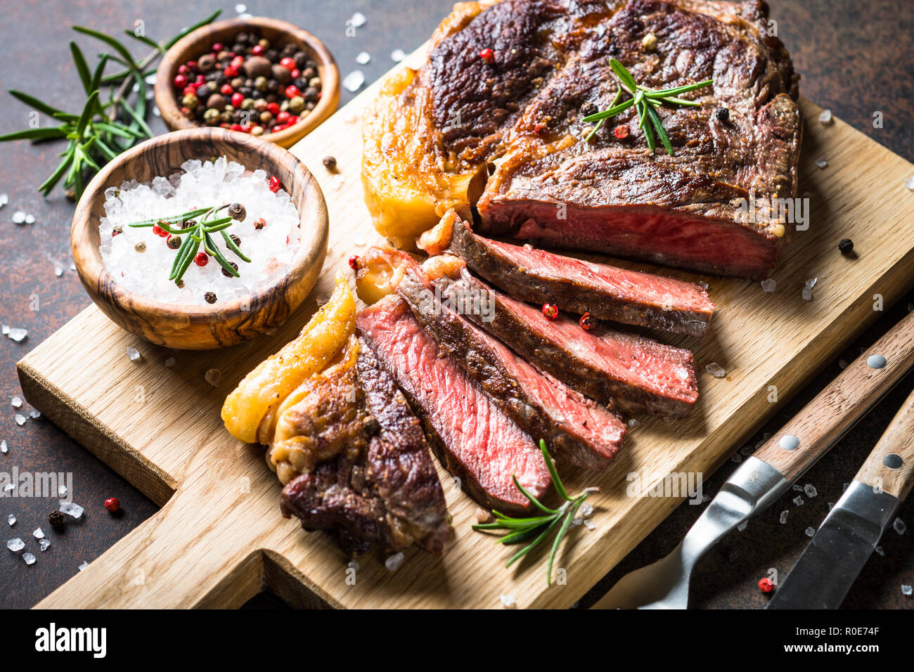 Grilled beef steak ribeye medium rare on wooden cutting board ...