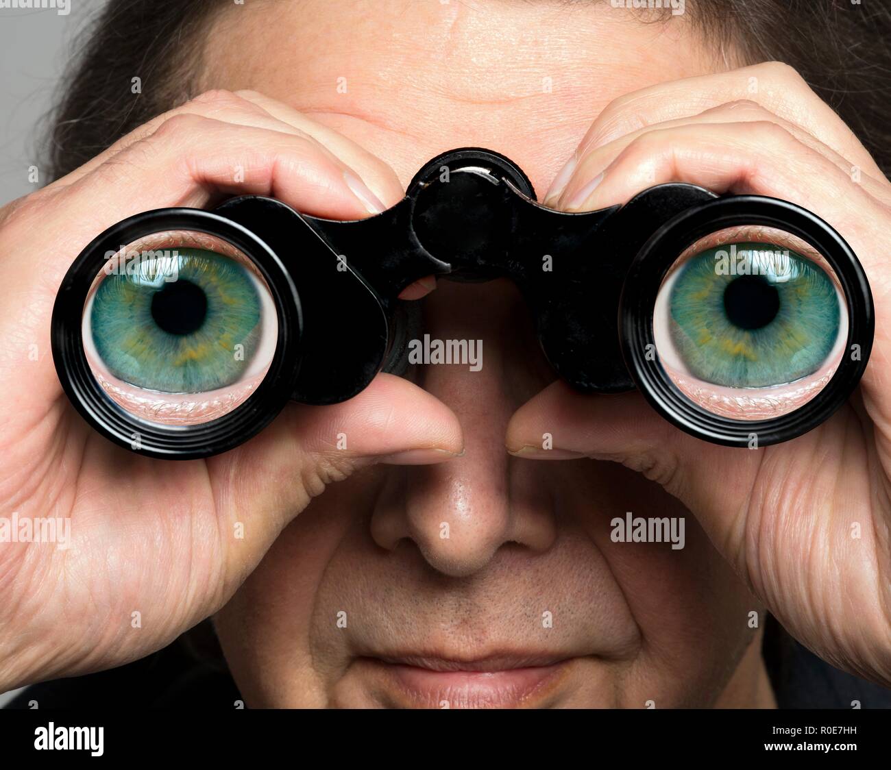 Man holding binoculars with eyes on lenses Stock Photo Alamy