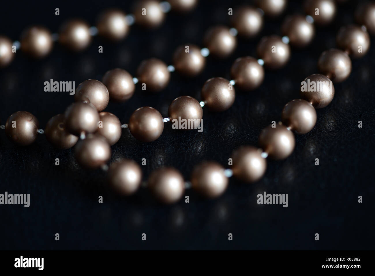 Long necklace of brown beads on a dark background close up Stock Photo