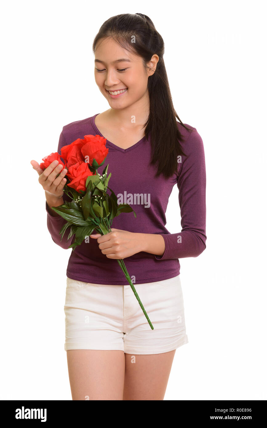 Young happy Asian teenage girl smiling holding red roses ready f Stock ...