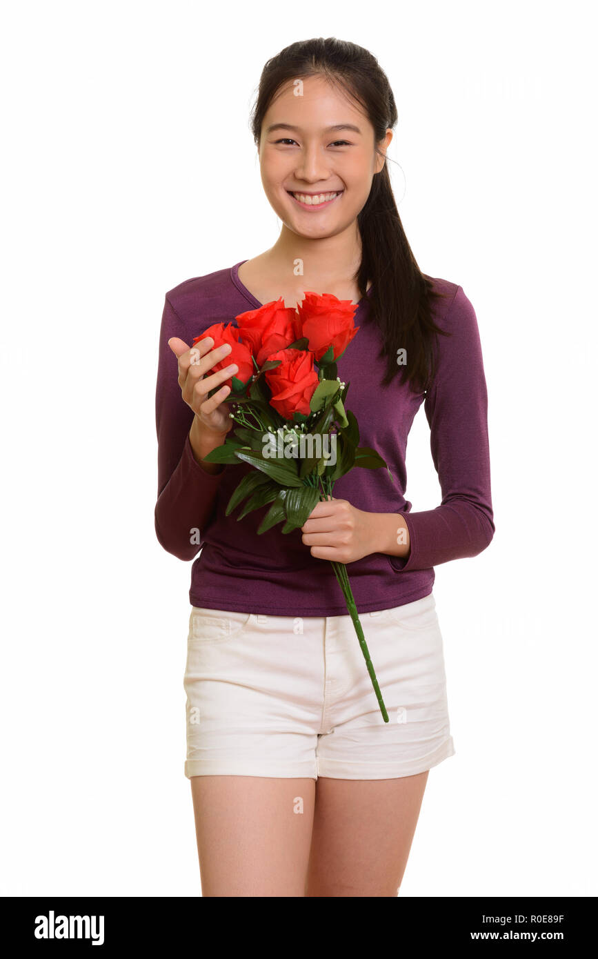 Young happy Asian teenage girl smiling holding red roses ready f Stock ...