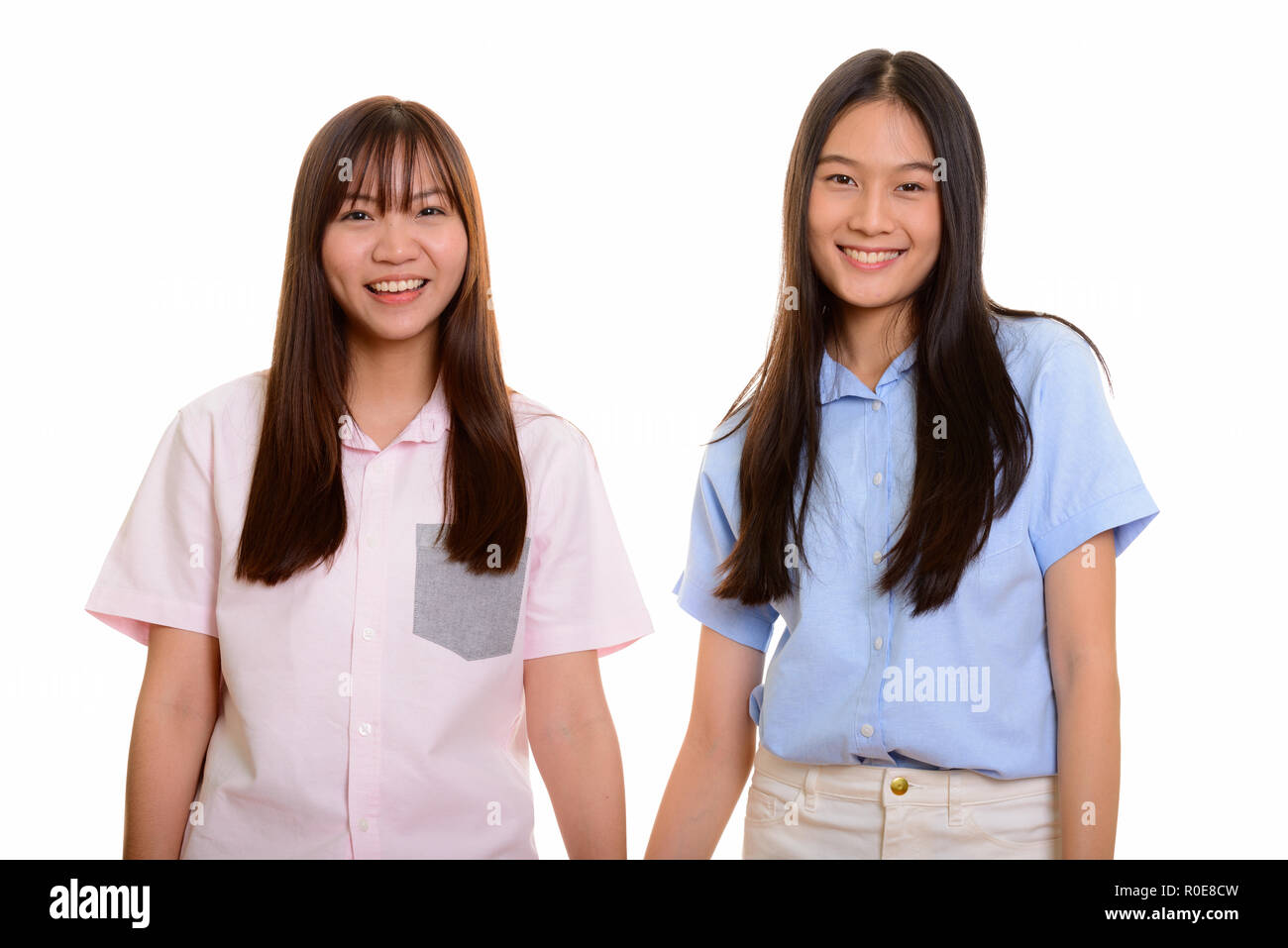 Studio shot of two young happy Asian teenage girls smiling Stock Photo