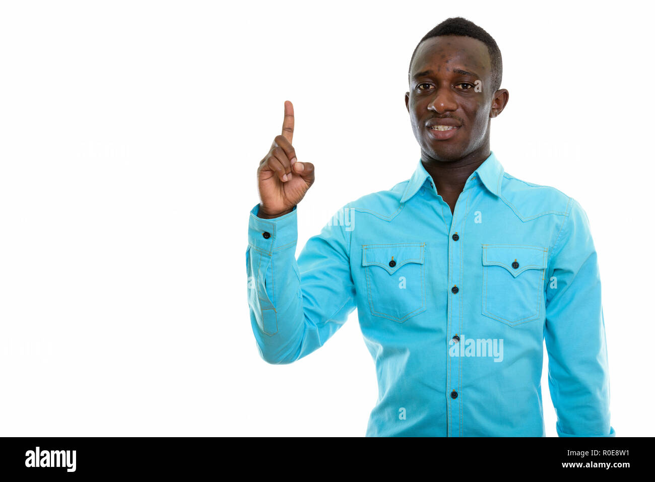 Studio shot of young happy black African man smiling while point Stock Photo