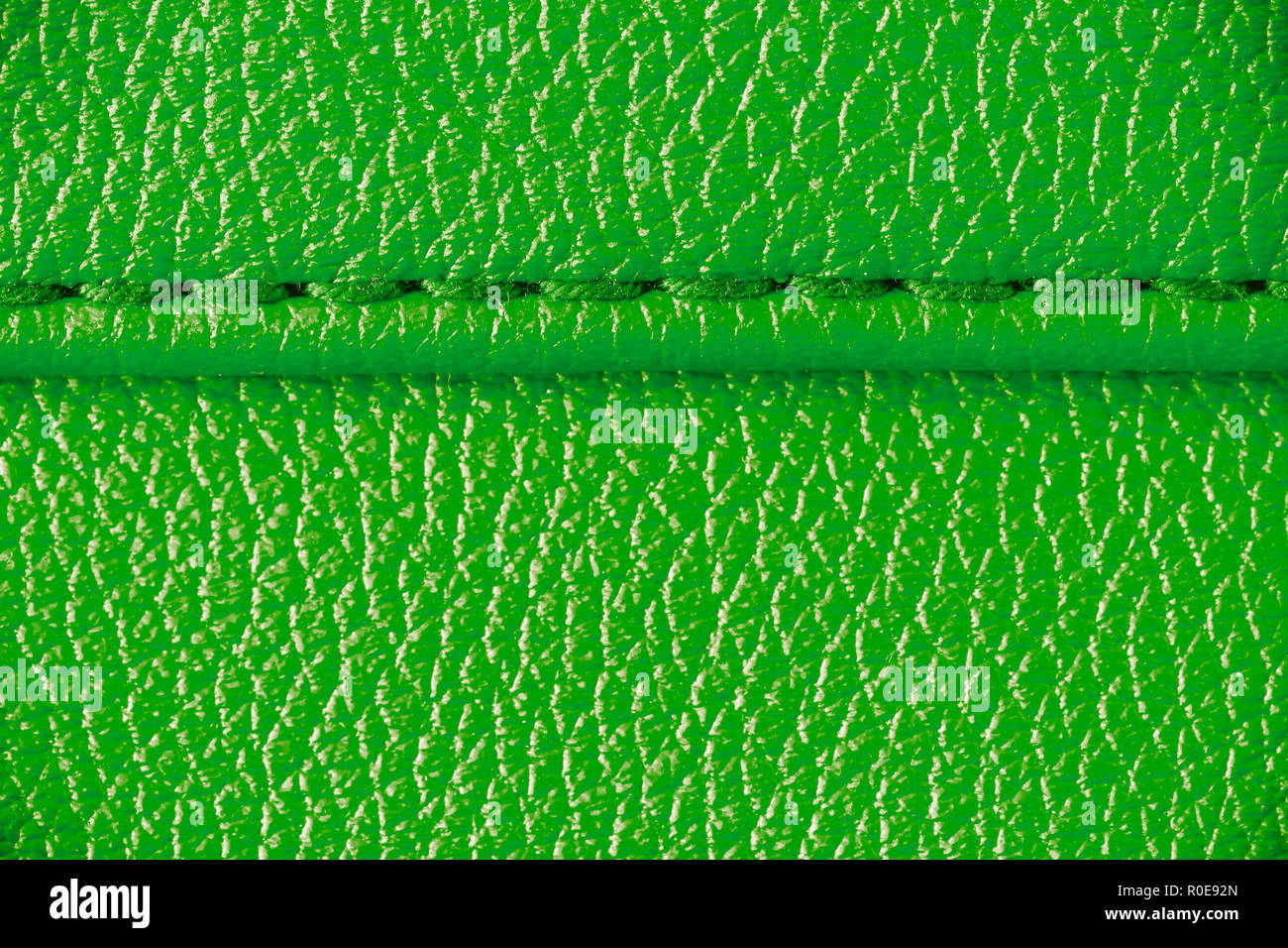 Two layers of green leather textile sewed stitched tightly together under high magnification close detail photography as surface texture background. Stock Photo
