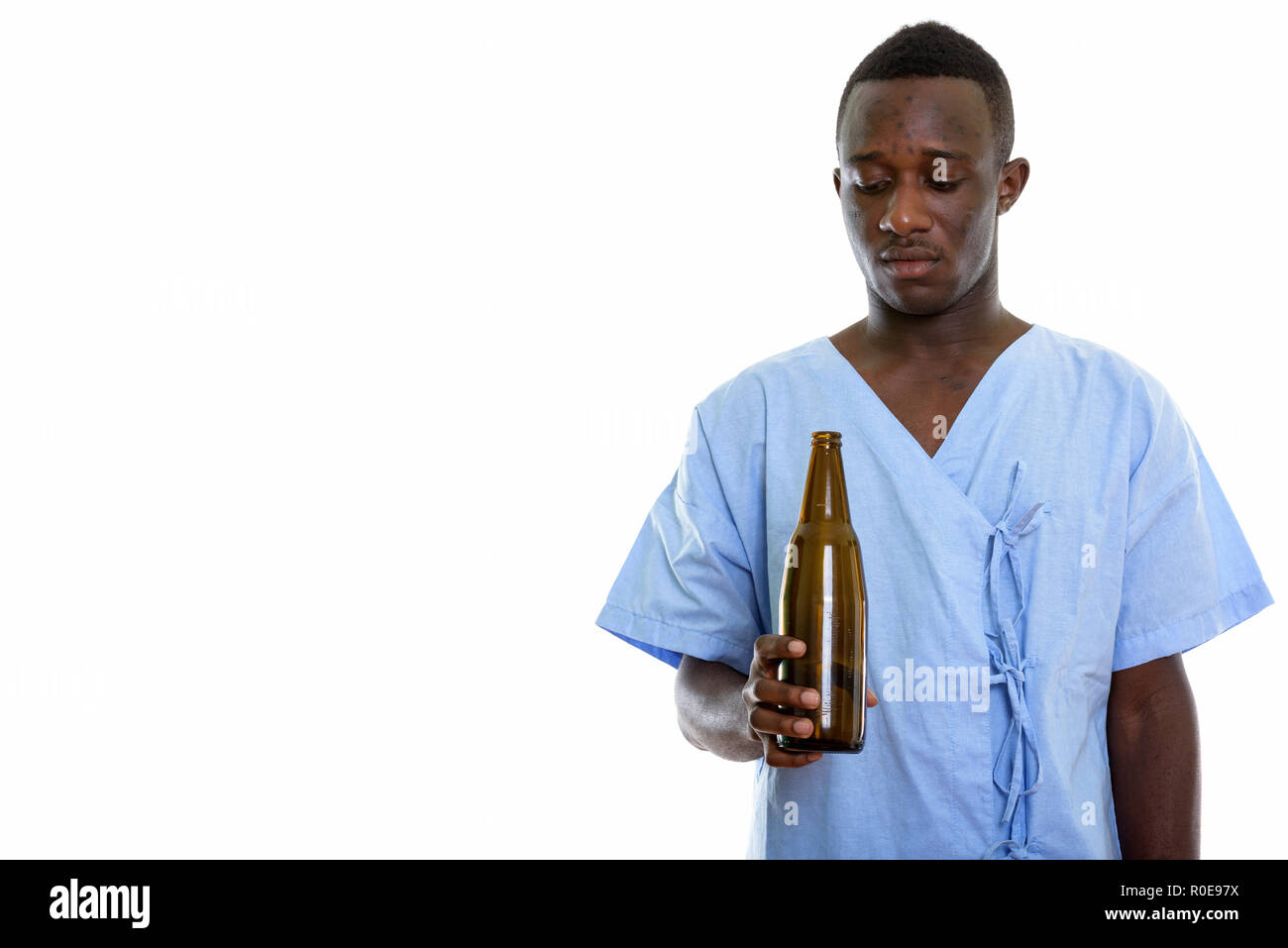 Studio shot of young black African man patient holding and looki Stock Photo