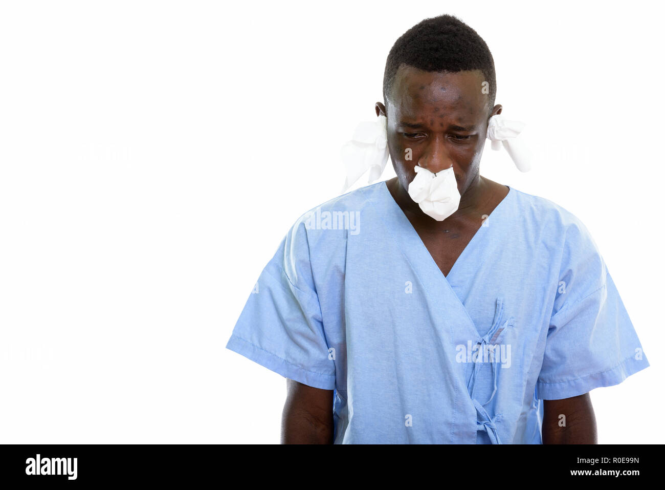 Studio shot of young black African man patient looking down and  Stock Photo