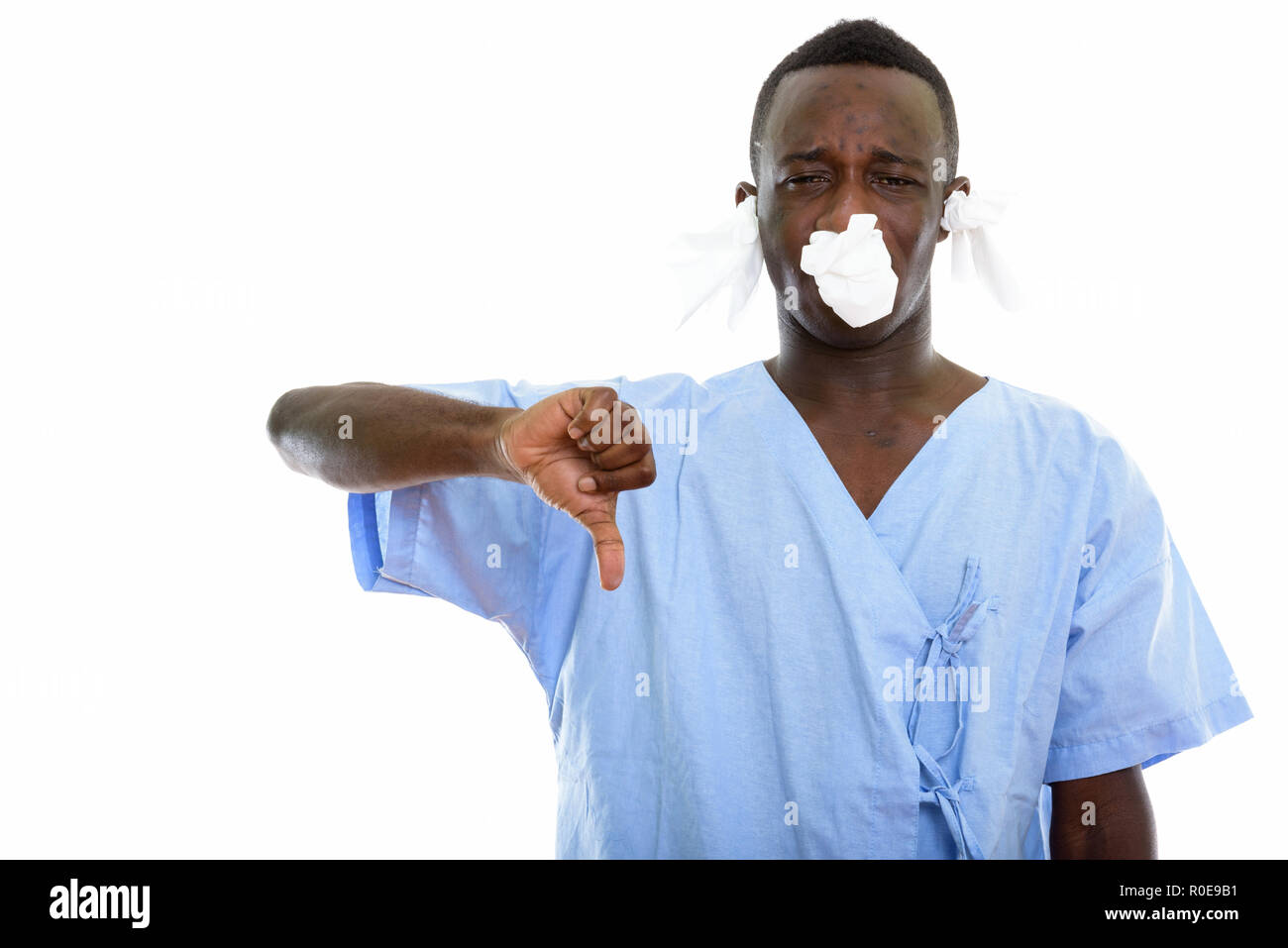 Studio shot of young black African man patient giving thumb down Stock Photo