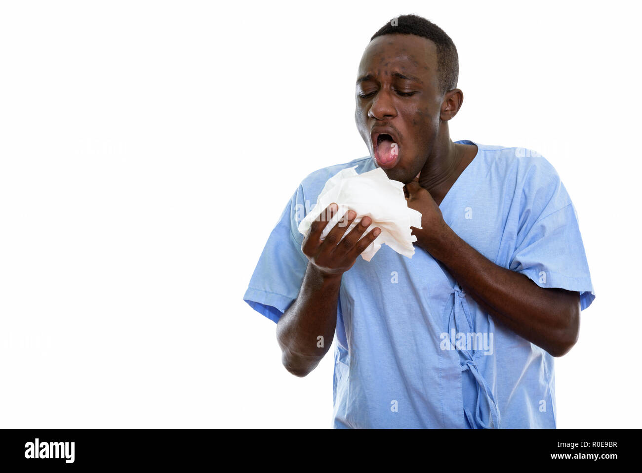 Studio shot of young black African man patient coughing on the t Stock Photo