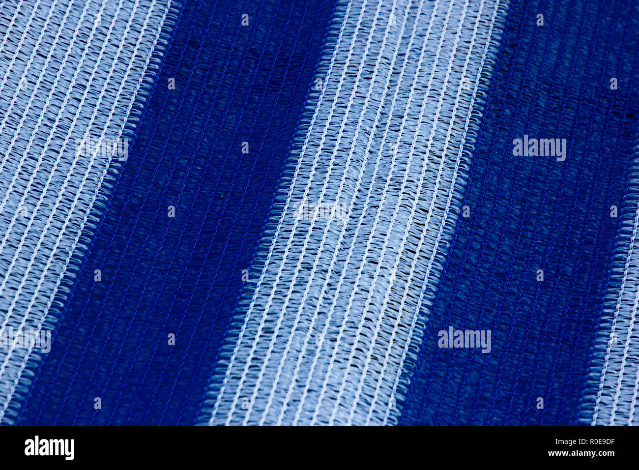 a beautiful white and blue stripey texture of a boat cover by the seaside Stock Photo