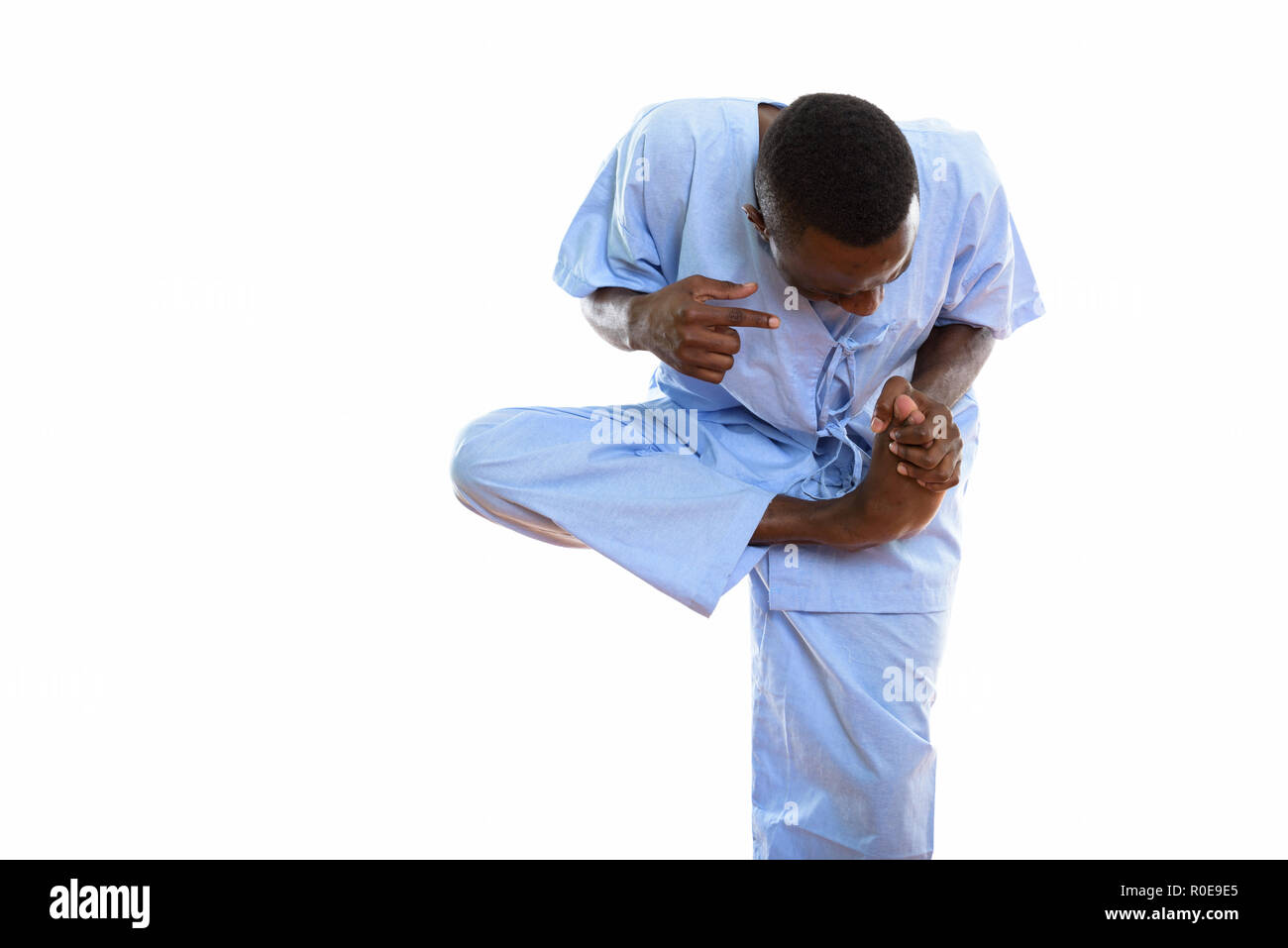 Studio shot of young black African man patient standing while ho Stock Photo