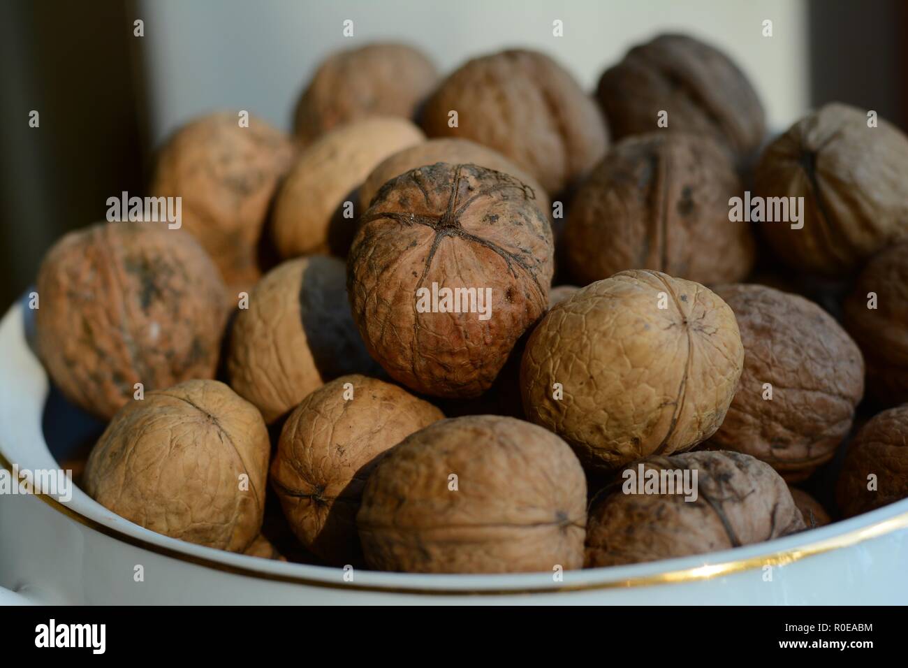 Unshelled walnuts in a bowl Stock Photo