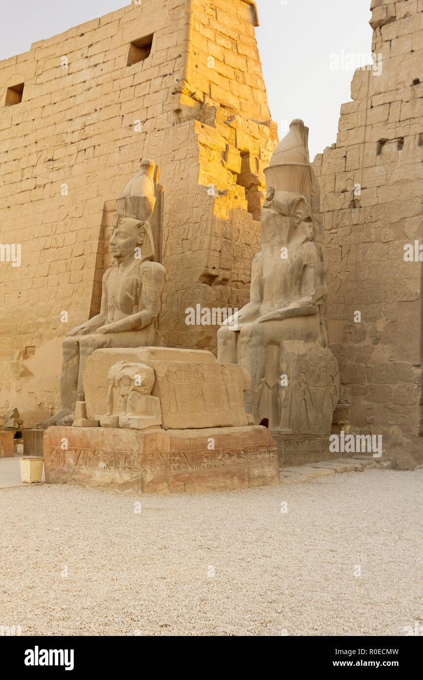 Two statues of the King Ramses II at the entrance to Luxor Temple ...