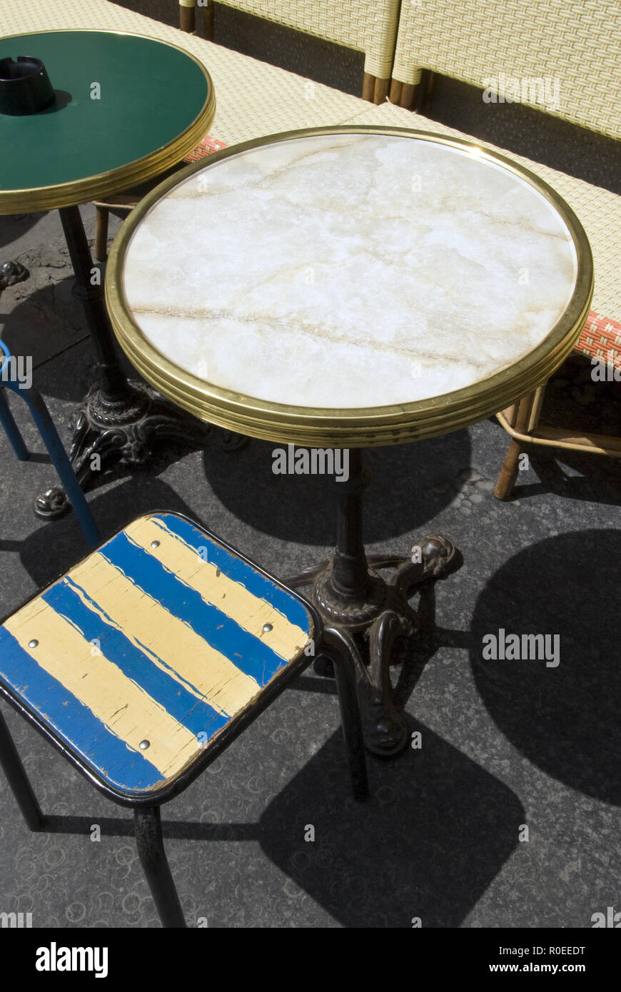 Colorful seats and traditional French bistro tables outside a cafe on