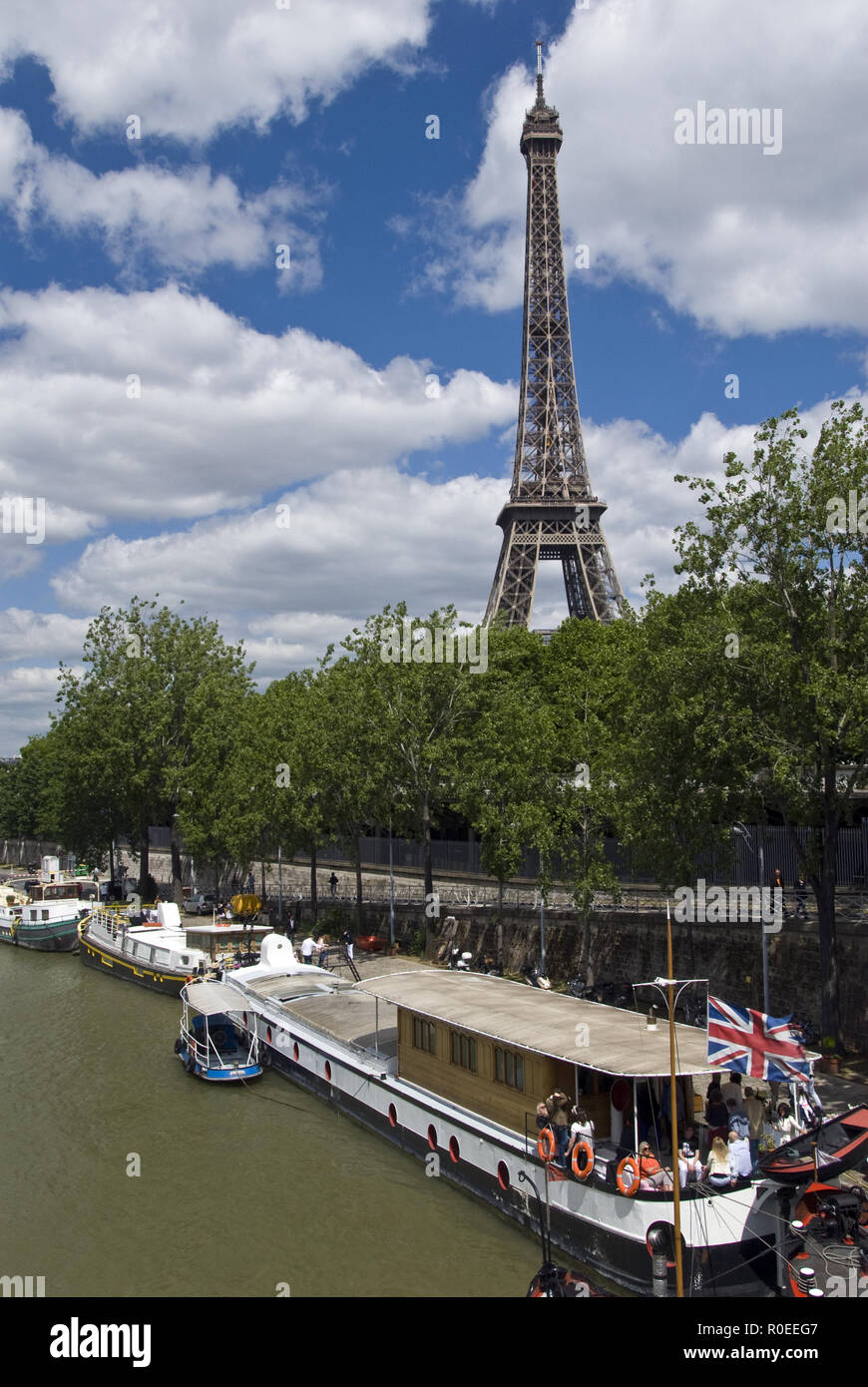 The Eiffel Tower (La Tour Eiffel) stands over boats moored on the Seine, Paris, France. Stock Photo