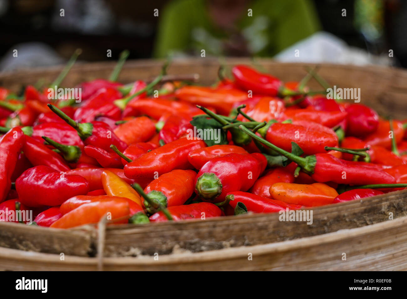 A wooden bowl filled with red chilis. Stock Photo