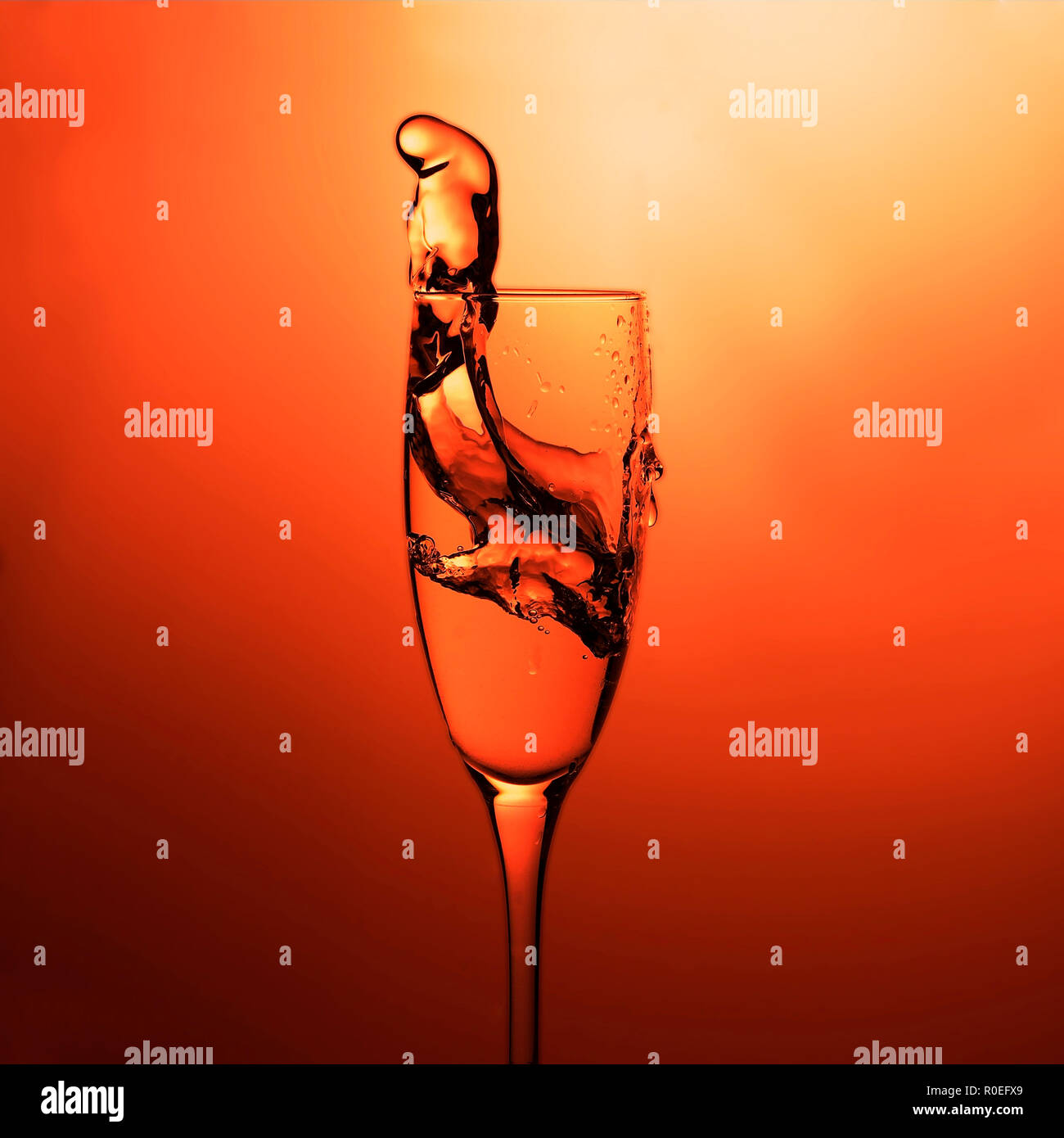 Elegant cocktail glass with splash of drink. Closeup view of the