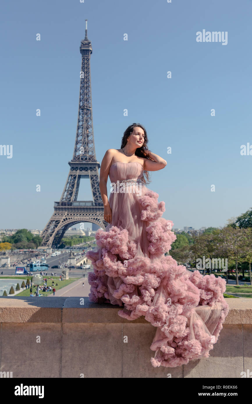 Beautiful hipster girl dressed to impress in a pastel pink ballroom dress  with Eiffel Tower in background Stock Photo - Alamy