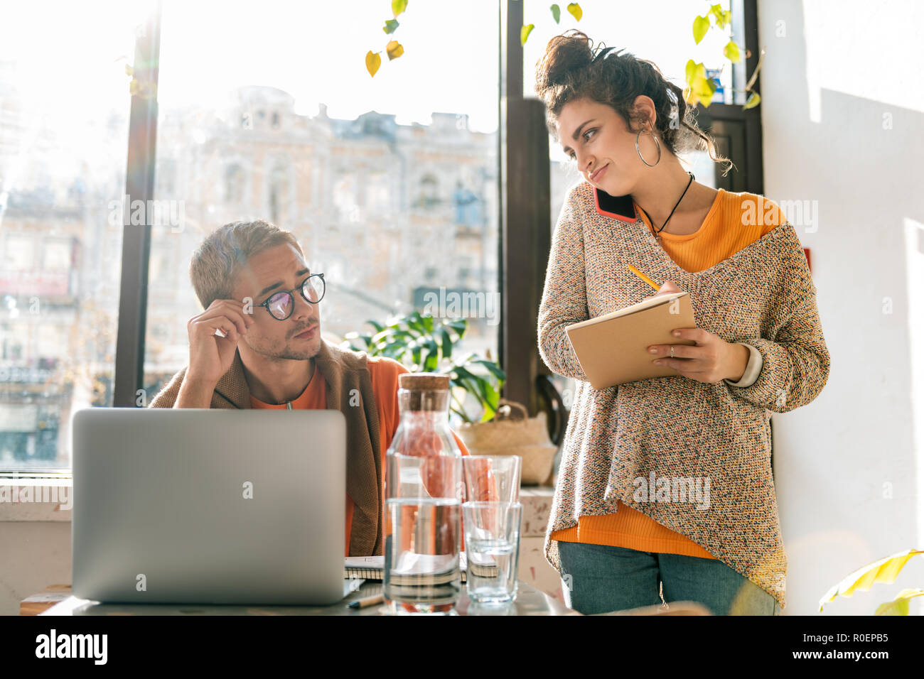 Dark-haired wife calling business partner standing near her husband Stock Photo