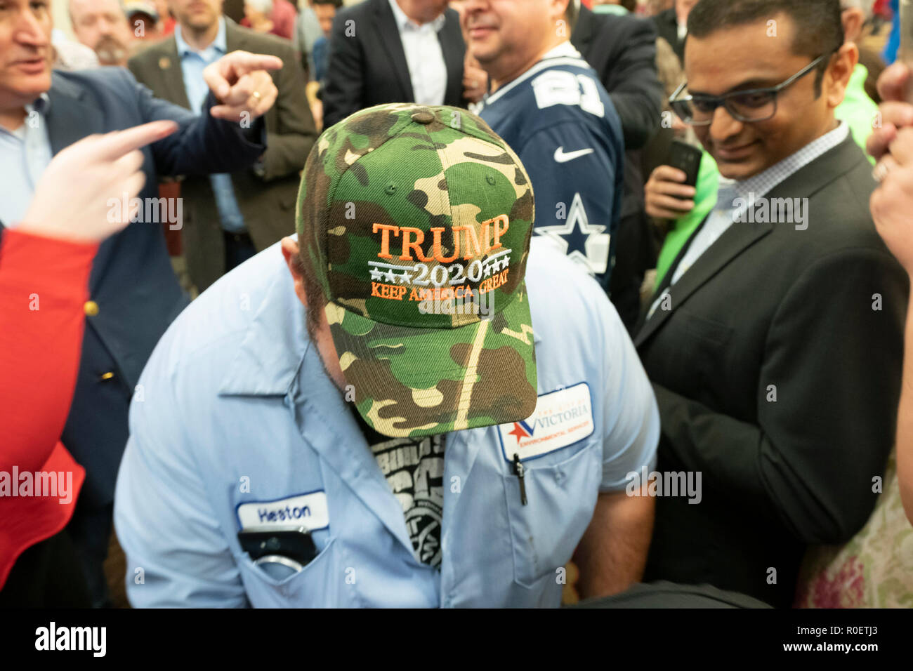 Man at a campaign rally for Republican U.S. Sen. Ted Cruz shows his support for Pres. Donald Trump with a TRUMP 2020 hat. Stock Photo