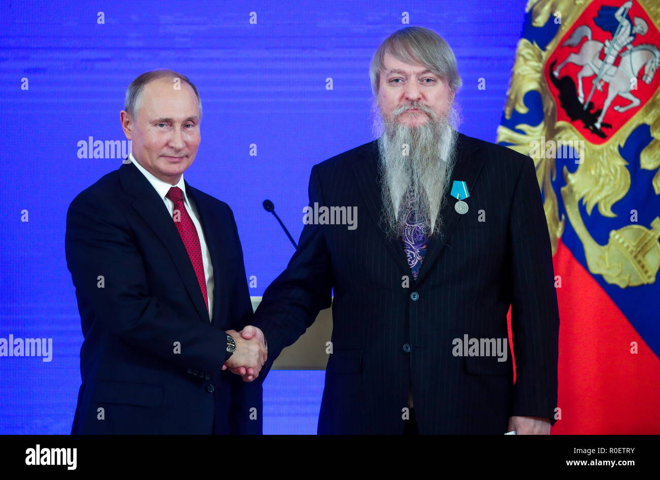 Sergei Provatorov, chairman of board of the all-Ukrainian union of public  organisations, Russkoye Sodruzhestvo (R), receives a Pushkin Medal from the President  of Russia Vladimir Putin at a ceremony to award foreign
