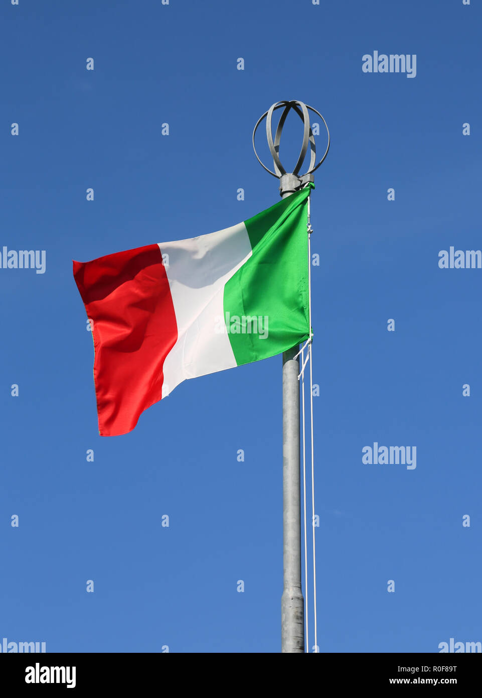Big Italian flag with colors red white and green waves on the blue sky Stock Photo