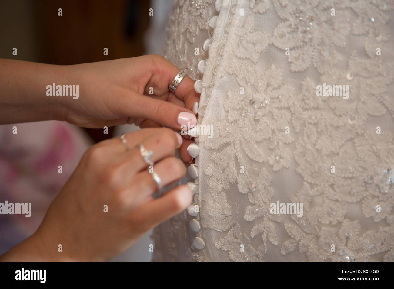 Close up of wedding dress being done up on the brides wedding day Stock Photo