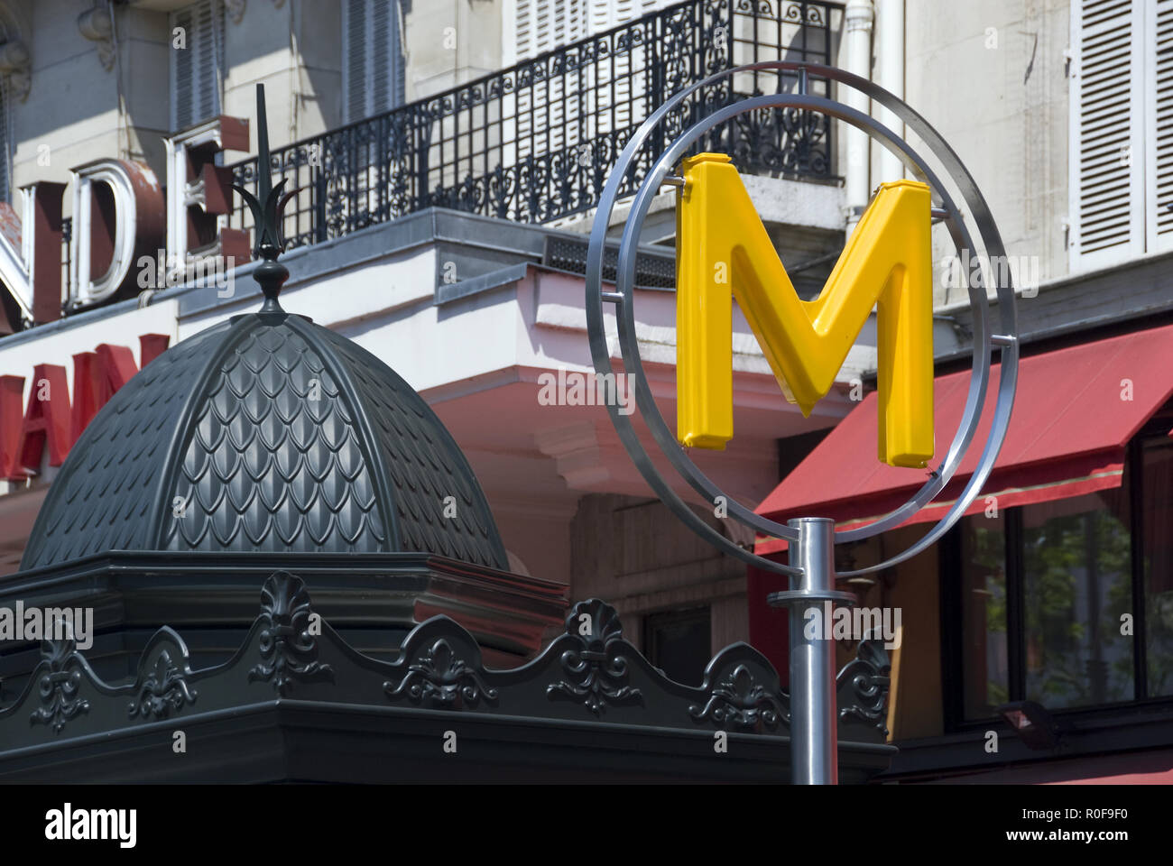 An Art Deco Metro (subway) sign on the Boulevard du Montparnasse, in front of La Rotonde, an historic cafe in the Montparnasse area of Paris, France. Stock Photo