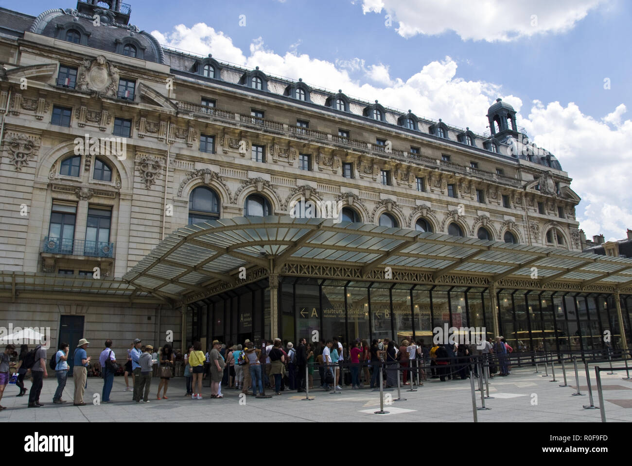 Tourists wait to enter the Musee d'Orsay, an art museum housed in the ...