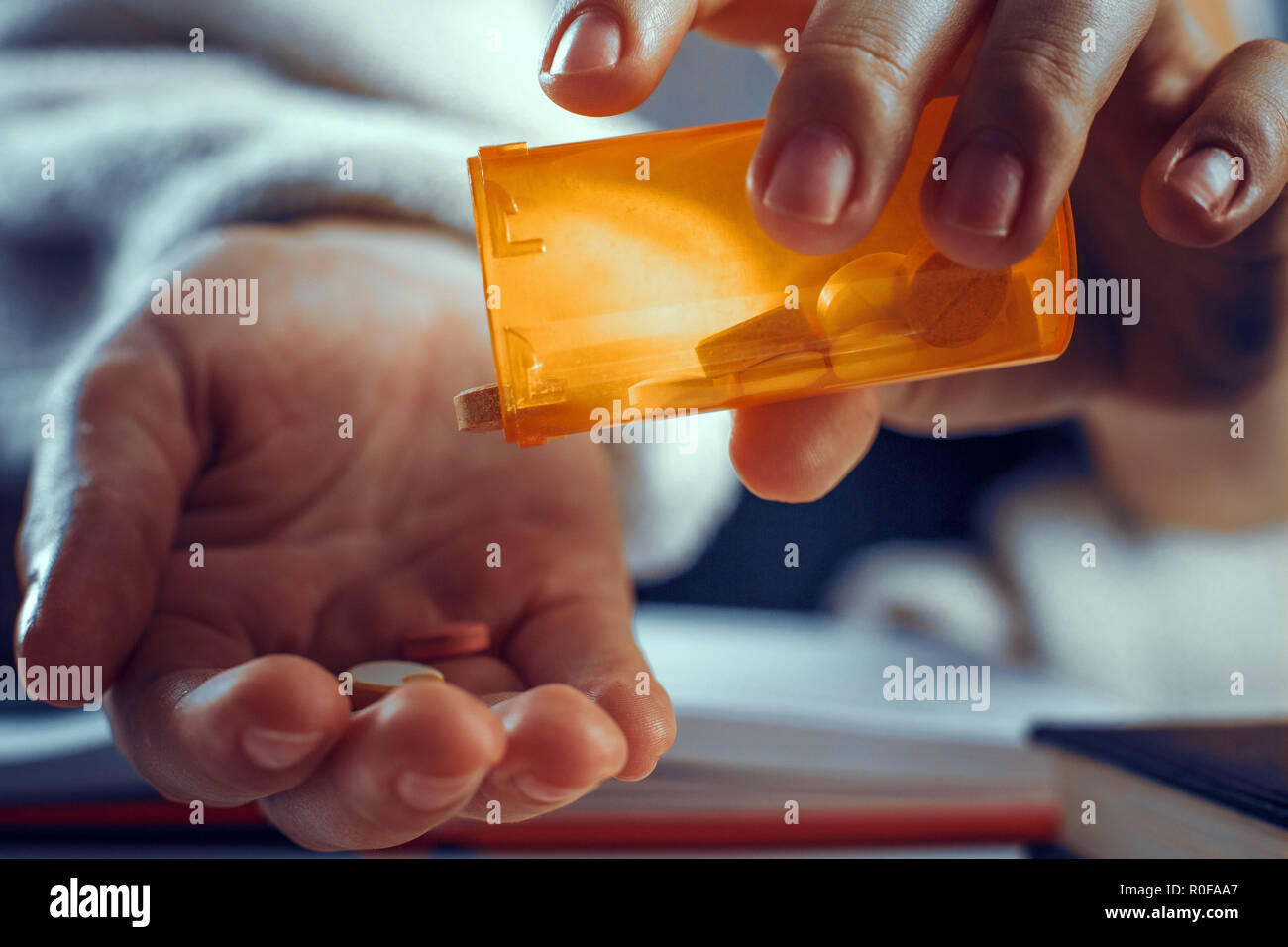 Close up look of hands while pouring the pills out of the bottle. Stock Photo