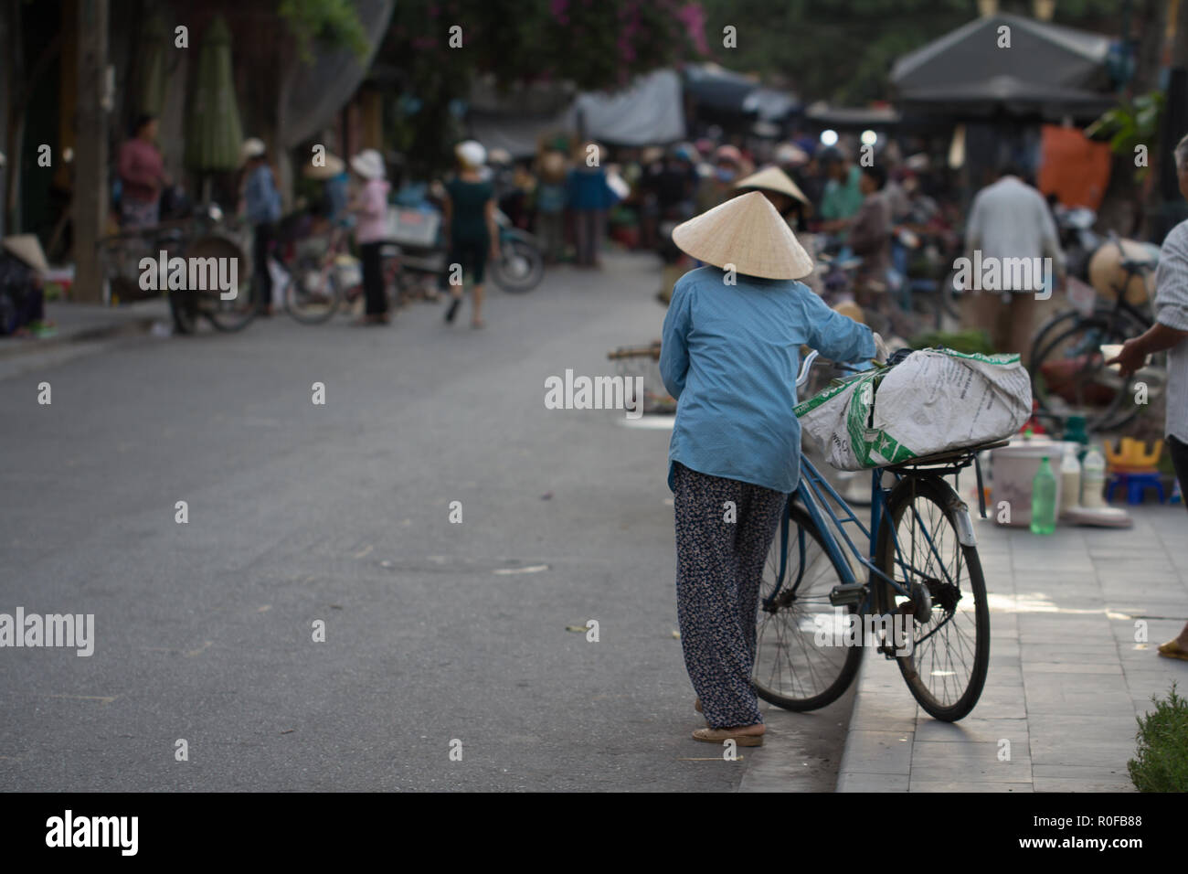 Woman with bicycle shopping on street market, Saigon, Vietnam. Stock Photo