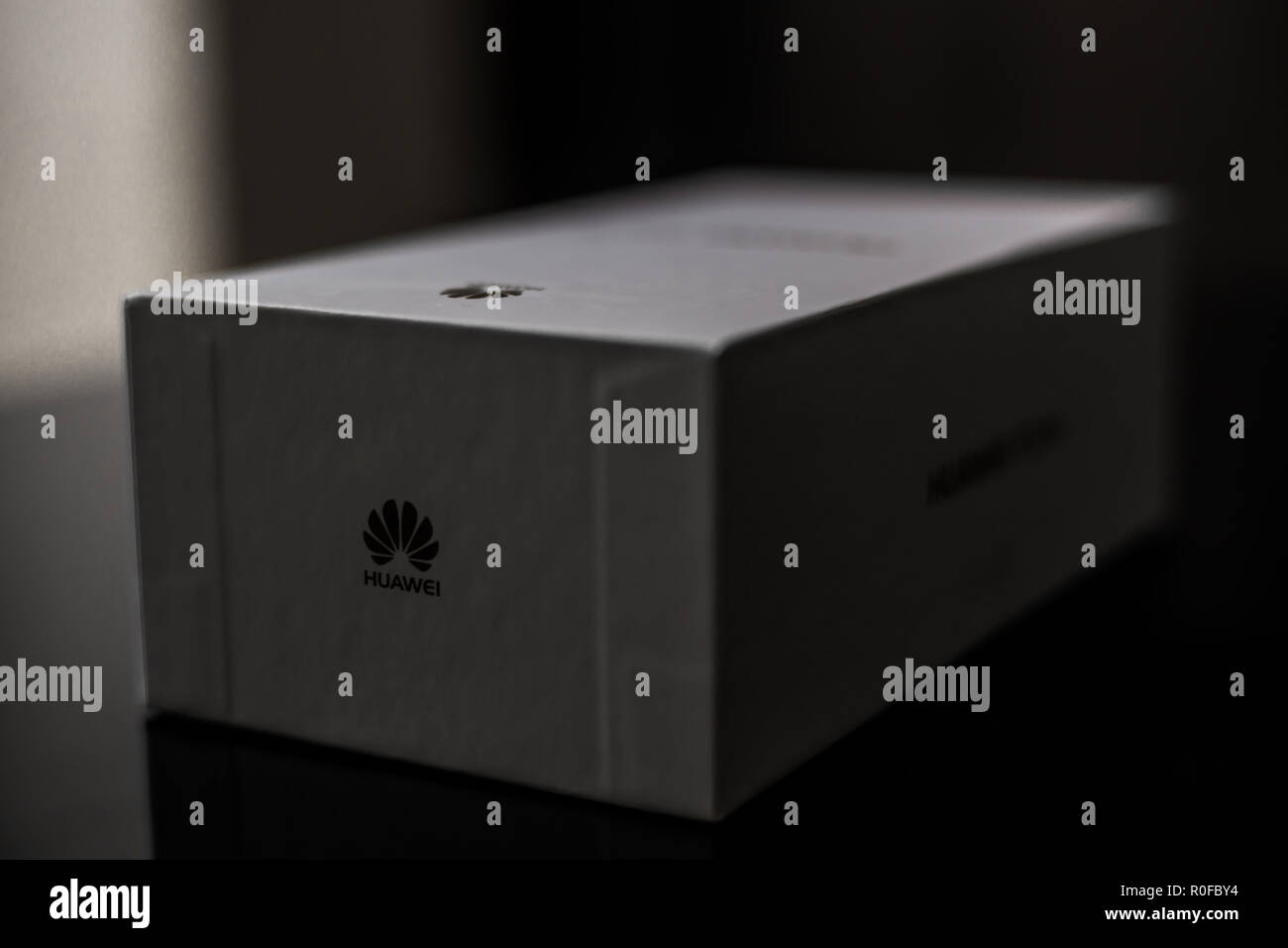 White box of a brand new P20 Lite mobile smartphone made by Chinese technology brand Huawei on a shiny black surface Stock Photo