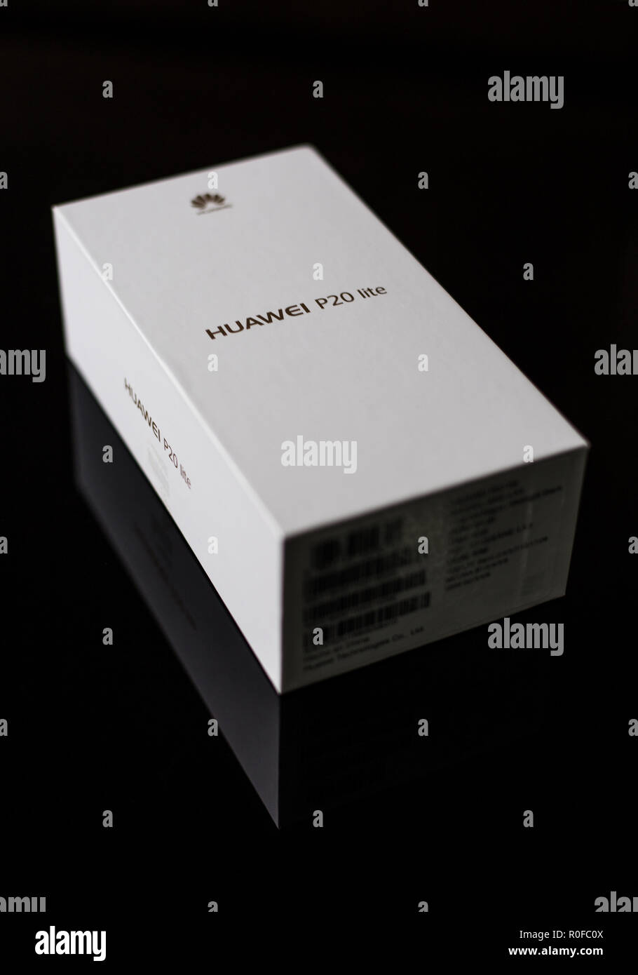 White box of a brand new P20 Lite mobile smartphone made by Chinese technology brand Huawei on a shiny black surface Stock Photo