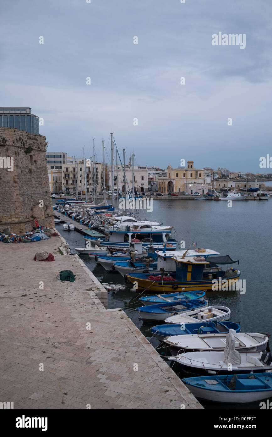 Colourful fishing boats in the harbour in the town of Gallipoli in the Salento Peninsula, Puglia, Southern Italy. Stock Photo