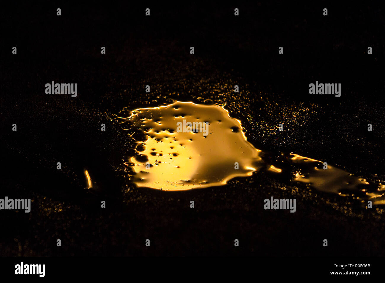 liquid gold is spilled in a dark room Stock Photo