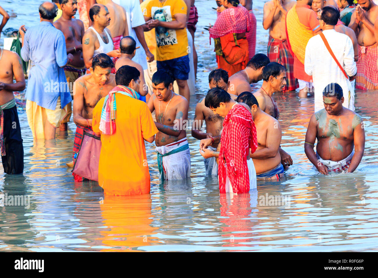 HARIDWAR, INDIA - JANUARY 14, 2016: Devotees taking holy dip at Har Ki Pauri on river Ganga on the first bath of Ardh Kumbh fair. People taking bath. Stock Photo