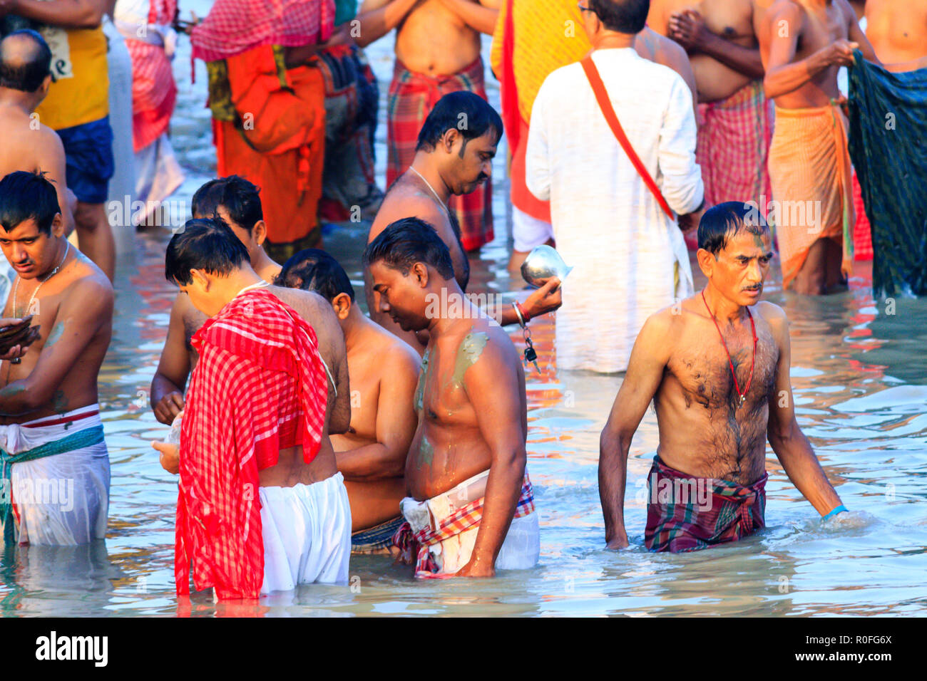 HARIDWAR, INDIA - JANUARY 14, 2016: Devotees taking holy dip at Har Ki Pauri on river Ganga on the first bath of Ardh Kumbh fair. People taking bath. Stock Photo