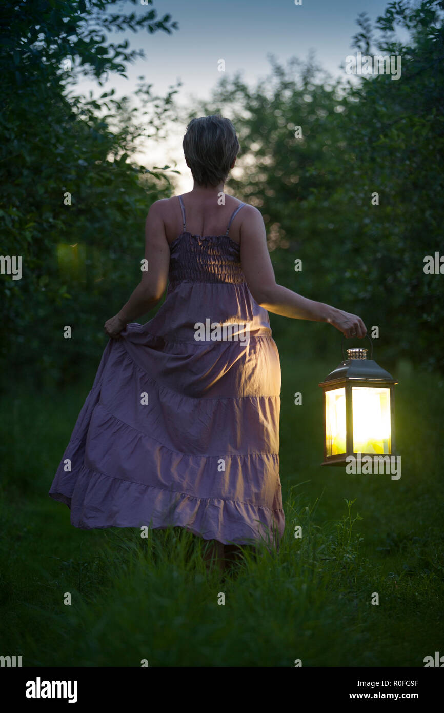 Woman with lantern in the middle of the night Stock Photo