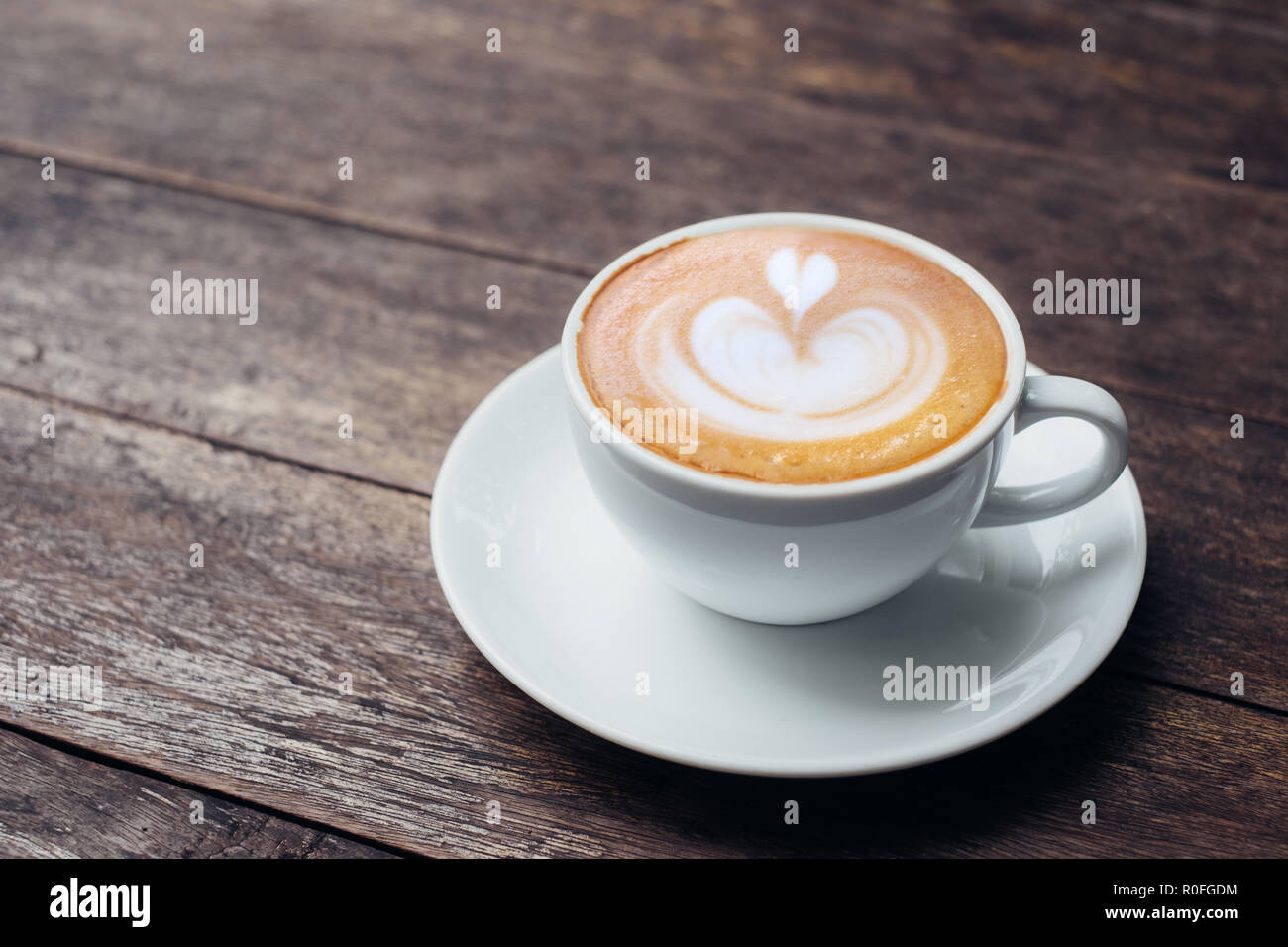 https://c8.alamy.com/comp/R0FGDM/close-up-white-coffee-cup-with-heart-shape-latte-art-on-grunge-wood-table-at-cafe-R0FGDM.jpg