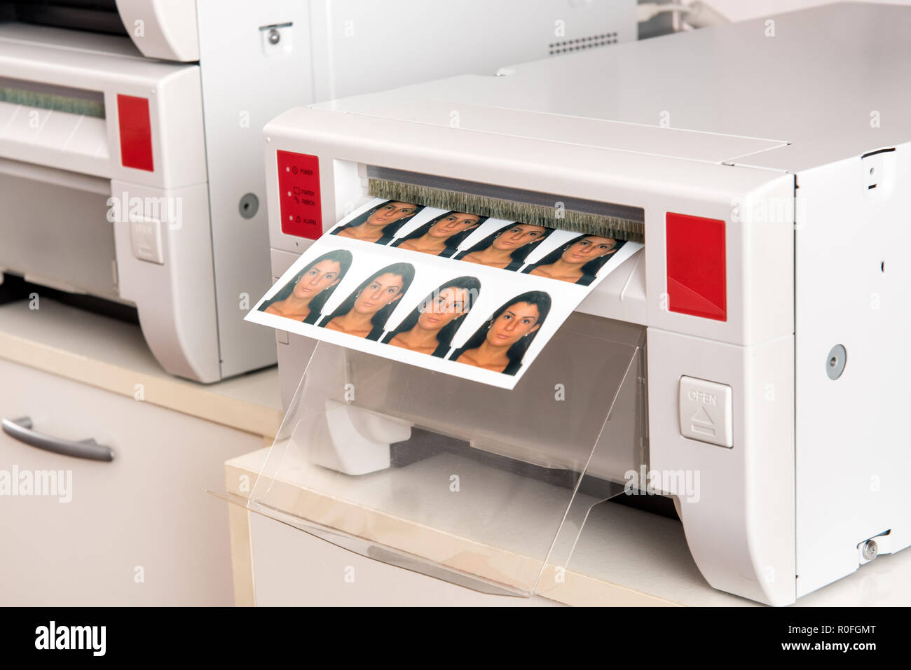 Printing passport photos of a woman on a printer with a sheet of